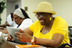 Harriet Carter-Brown, 63, of Washington, D.C., smiles as she looks at photos of lighthouses on her iPad during the twice weekly Connect to Community class in the basement of Shiloh Baptist Church in Washington, D.C., on July 9, 2013.